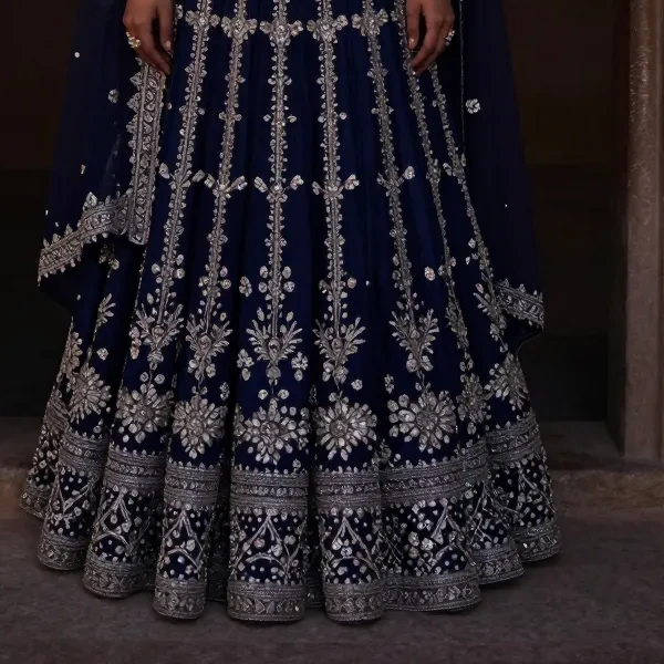 Dense silver thread work on the hem of a midnight indigo lehenga